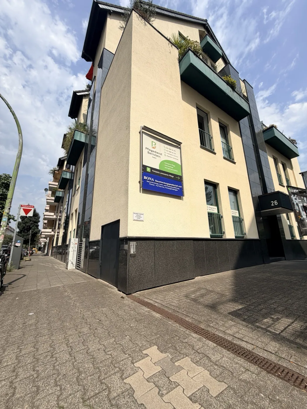 Außenansicht des Hauptsitzes an der Mettmanner Straße in Düsseldorf, heller Neubau mit Firmenschild an der Straßenecke