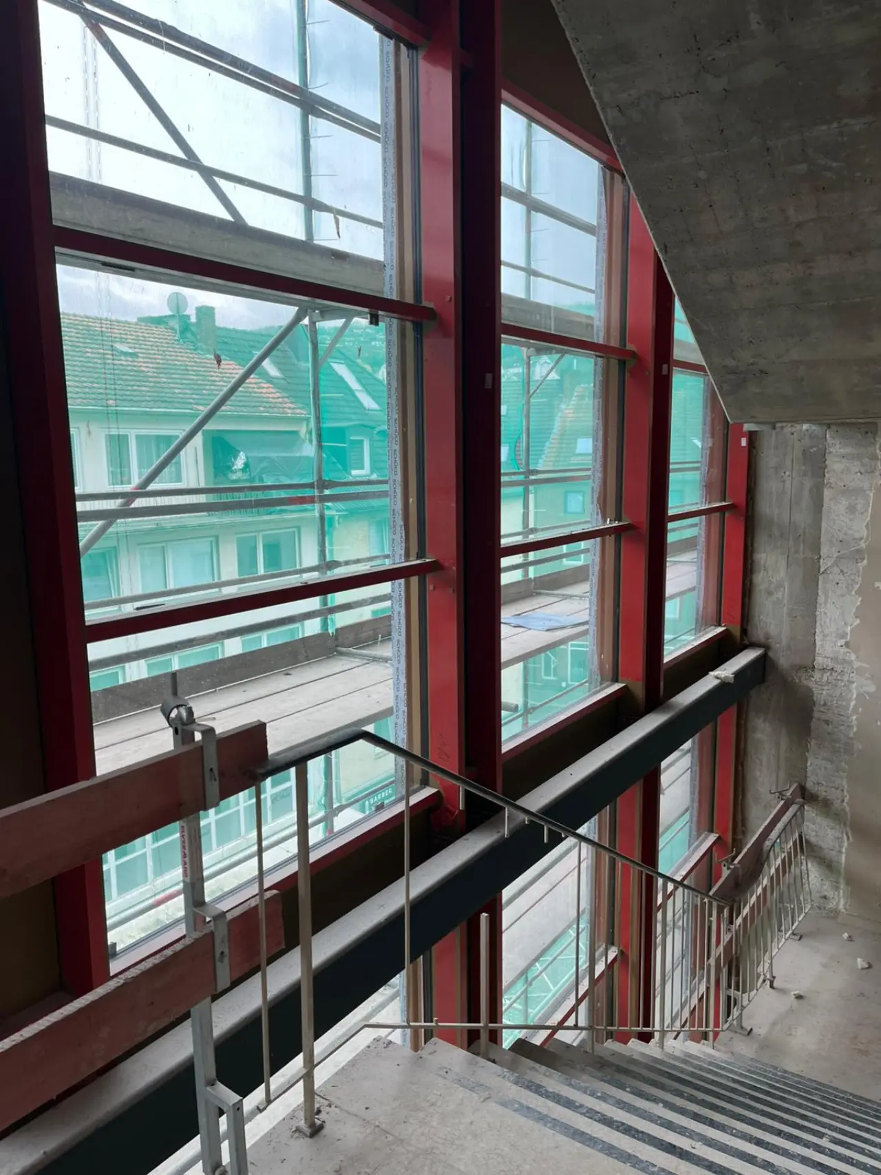 Treppenhaus mit großer Fensterfront im Rohbau, Aufnahme aus der Bauphase im März 2026